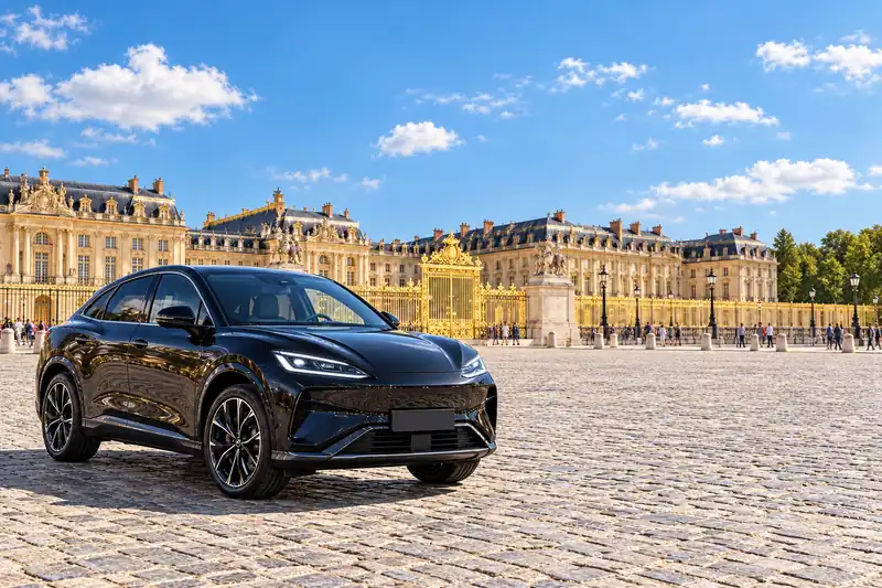 Taxi Versailles : la BYD Sealion 7 noire de PeaceDrive VTC sur la place d'Armes, devant le château, en plein jour